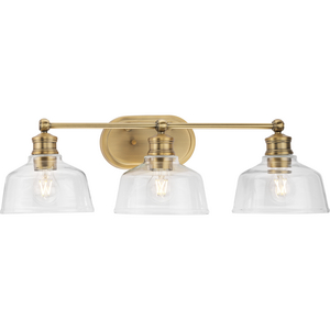 Singleton Collection Three-Light 26.5" Vintage Brass Farmhouse Vanity Light with Clear Glass Shades