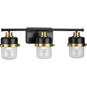 Beckner Collection Three-Light Matte Black Clear Glass Urban Industrial Bath Light with Vintage Brass Accents